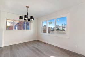 Unfurnished dining area featuring light wood-style floors and a chandelier