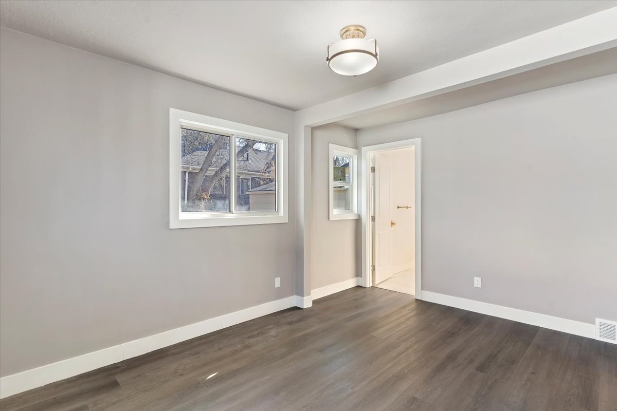 Empty room with baseboards and dark wood finished floors