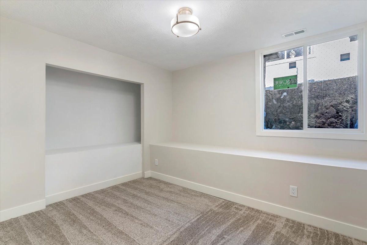 Carpeted spare room featuring baseboards and a textured ceiling