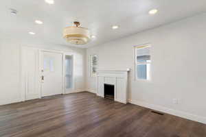 Foyer entrance with dark wood-style floors, a fireplace, and recessed lighting