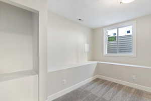 Spare room with baseboards and light carpet