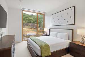 Bedroom featuring light carpet, expansive windows, and access to outside
