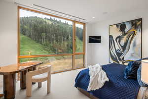 Bedroom with carpet flooring and a wall of windows