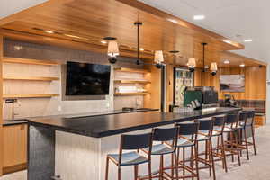 Indoor wet bar featuring dark countertops, open shelves, wooden ceiling, recessed lighting, and pendant lighting