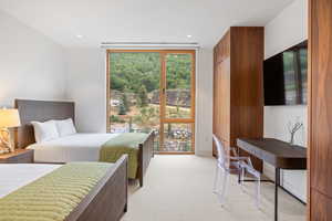 Bedroom featuring light carpet, expansive windows, access to outside, and recessed lighting