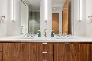 Full bath featuring double vanity, a stall shower, and recessed lighting