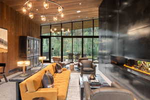 Community lobby featuring wooden walls, floor to ceiling windows, wood ceiling, and a high ceiling