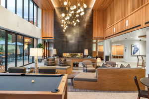 Building lobby with a towering ceiling, wooden walls, and recessed lighting