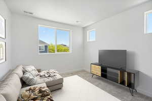 Living area with light colored carpet and baseboards