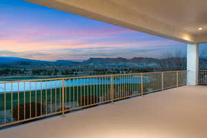Balcony at dusk with a patio and a water and mountain view