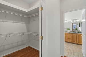 Walk in closet with light wood-type flooring