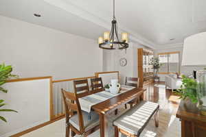 Dining room with light wood-style flooring and a chandelier