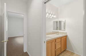 Full bathroom with double vanity and baseboards