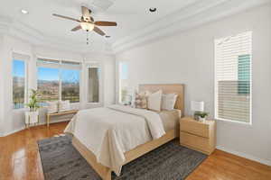 Bedroom featuring light wood-style floors, a tray ceiling, ceiling fan, and recessed lighting
