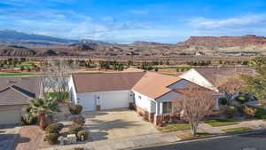 View of front of home with concrete driveway, a mountain view, and stucco siding