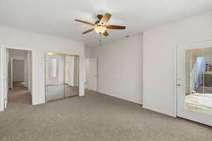 Unfurnished bedroom with light carpet, a ceiling fan, and a closet