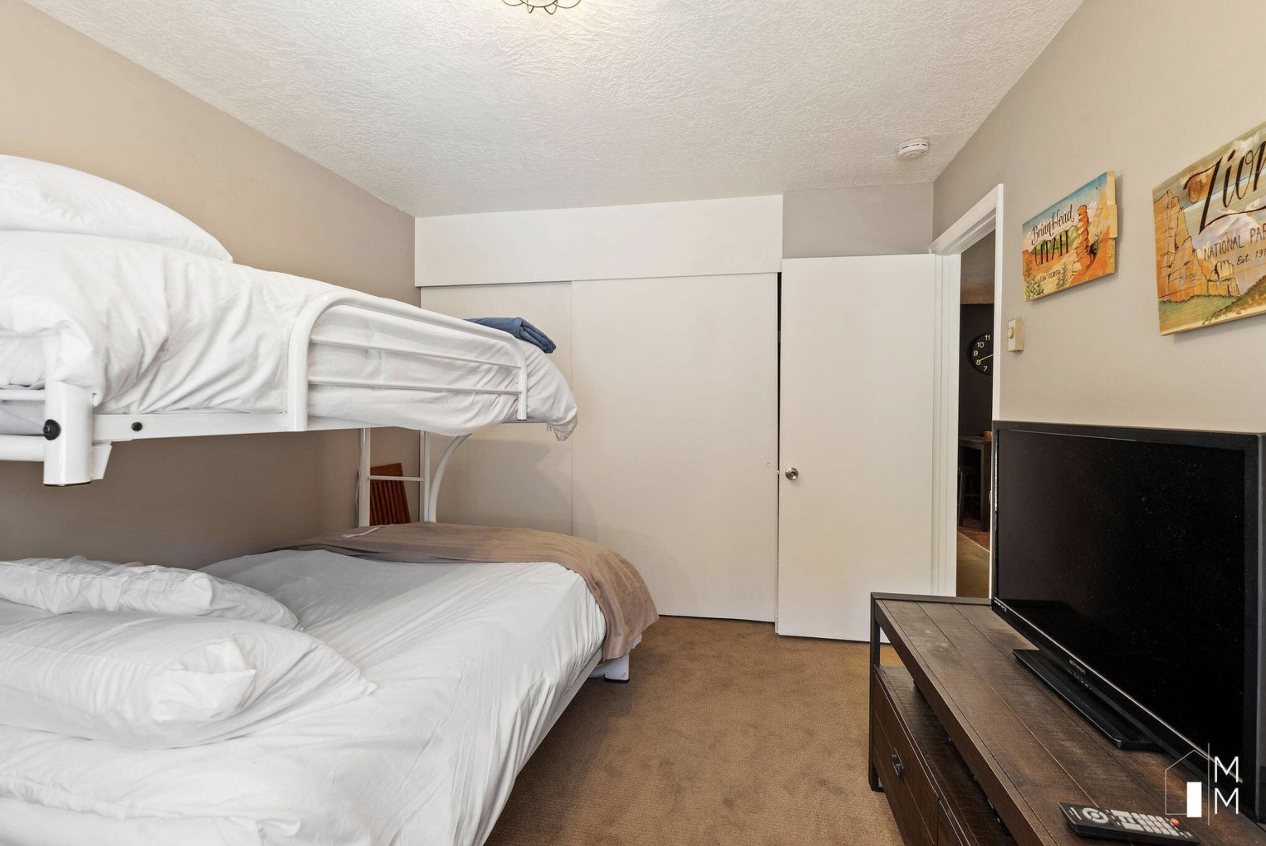 Carpeted bedroom featuring a textured ceiling and a closet