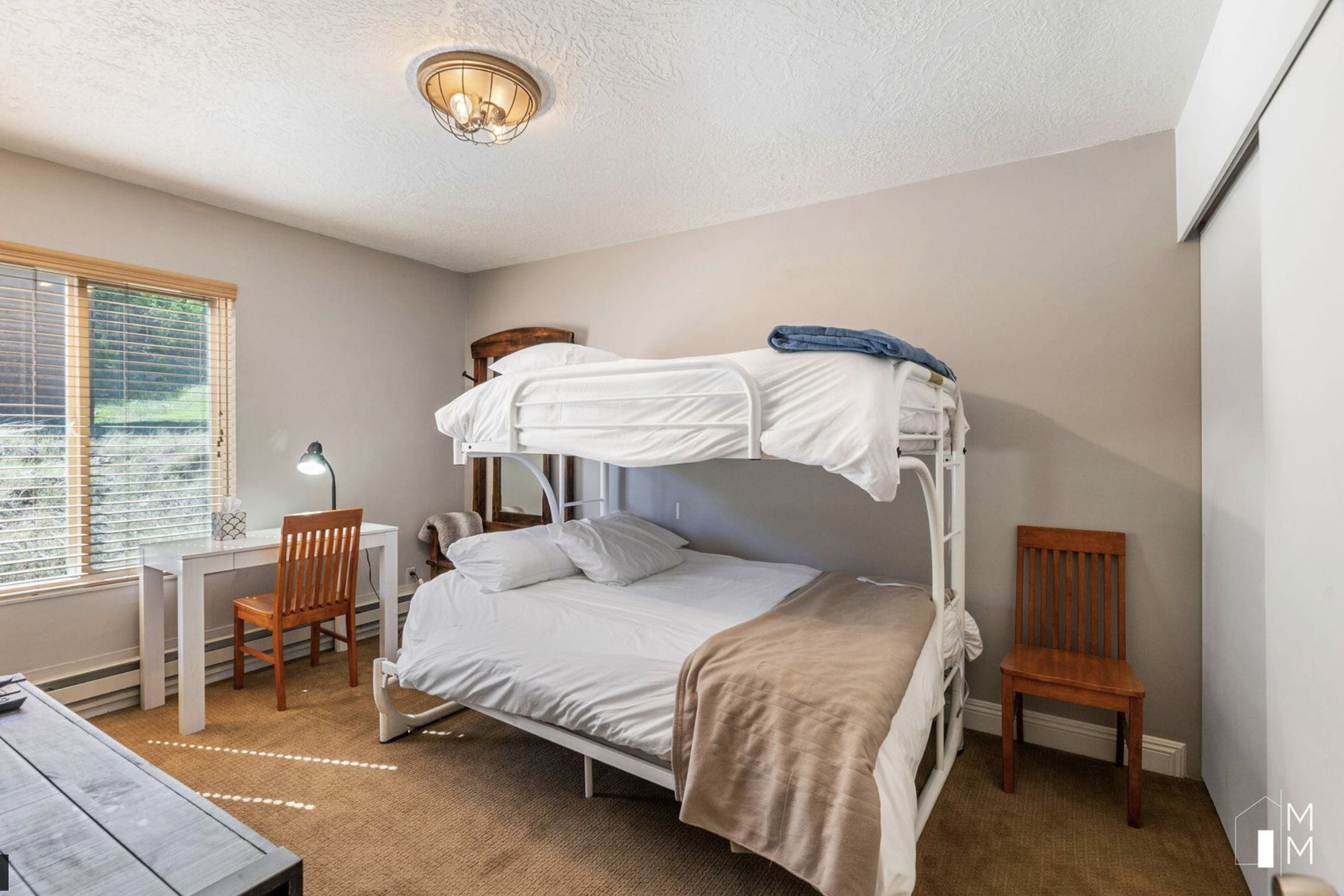 Bedroom with carpet floors, a textured ceiling, and baseboard heating