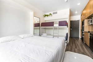 Bedroom featuring dark wood-style floors and high quality fridge