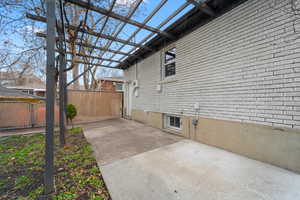 View of side of home featuring brick siding and a gate