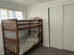Carpeted bedroom with a closet and baseboards