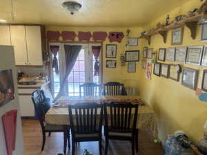 Dining room featuring a textured ceiling and light wood-style floors