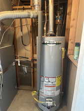Utility room featuring gas water heater and heating unit