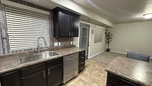 Kitchen with dark countertops, dishwasher, dark cabinetry, and light tile patterned floors