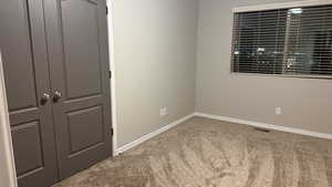 Empty room featuring carpet and baseboards