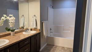 Full bath with double vanity and shower / washtub combination