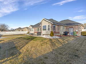 Rear view of property with brick siding, a patio area, and roof with shingles