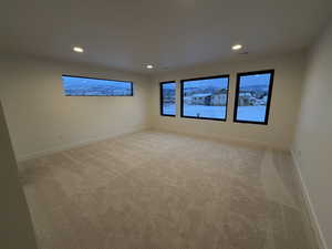Owners suite  with light carpet, large windows and recessed lighting