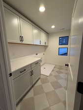 Laundry area featuring light flooring, recessed lighting, cabinet space, hookup for a washing machine, and electric dryer hookup