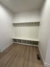Mudroom with light wood-type flooring and baseboards