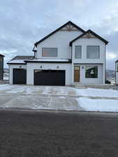 Modern farmhouse style home featuring driveway, board and batten siding, and a garage