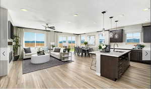 Kitchen with a kitchen breakfast bar, open floor plan, an island with sink, recessed lighting, and decorative light fixtures