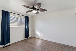 Unfurnished room featuring wood finished floors and ceiling fan