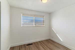 Empty room featuring a textured ceiling and wood finished floors