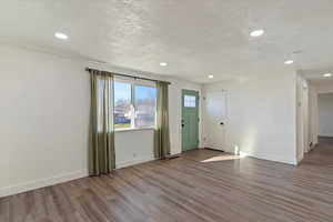 Entrance foyer featuring wood finished floors, a textured ceiling, and recessed lighting