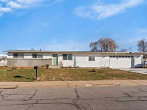 Ranch-style house with a front lawn, driveway, and an attached garage
