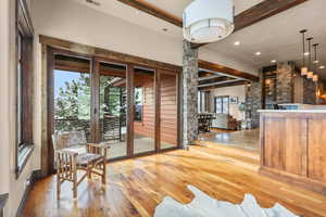 Interior space featuring beam ceiling, light wood-type flooring, ornate columns, and recessed lighting