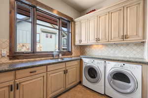 Laundry room featuring independent washer and dryer, light tile patterned flooring, and cabinet space