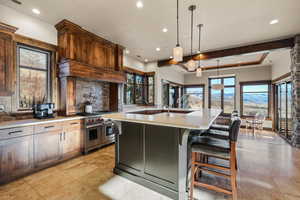 Kitchen featuring pendant lighting, backsplash, a breakfast bar, recessed lighting, and an island with sink