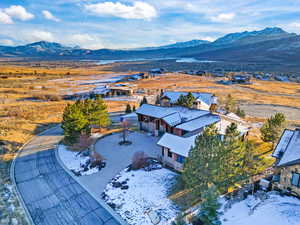 Snowy aerial view featuring a mountain view and a residential view