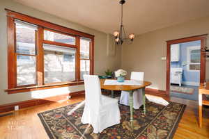 Dining space with healthy amount of natural light, light wood-style flooring, and a chandelier