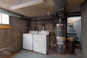 Below grade area featuring water heater and separate washer and dryer
