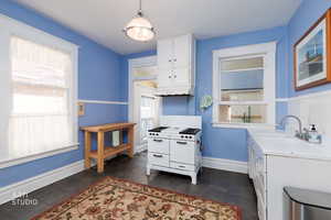 Kitchen with white cabinets, light countertops, double oven range, and healthy amount of natural light