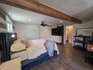Bedroom with a barn door, dark wood-type flooring, beam ceiling, recessed lighting, and ceiling fan