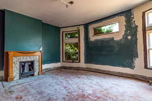 Unfurnished living room with healthy amount of natural light and a fireplace