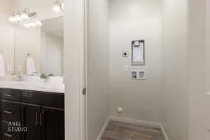Laundry room with hookup for a washing machine, wood finished floors, and hookup for an electric dryer